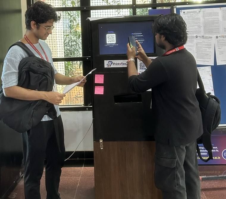 A student scanning the QR code on the PrintnFlow kiosk screen with their phone