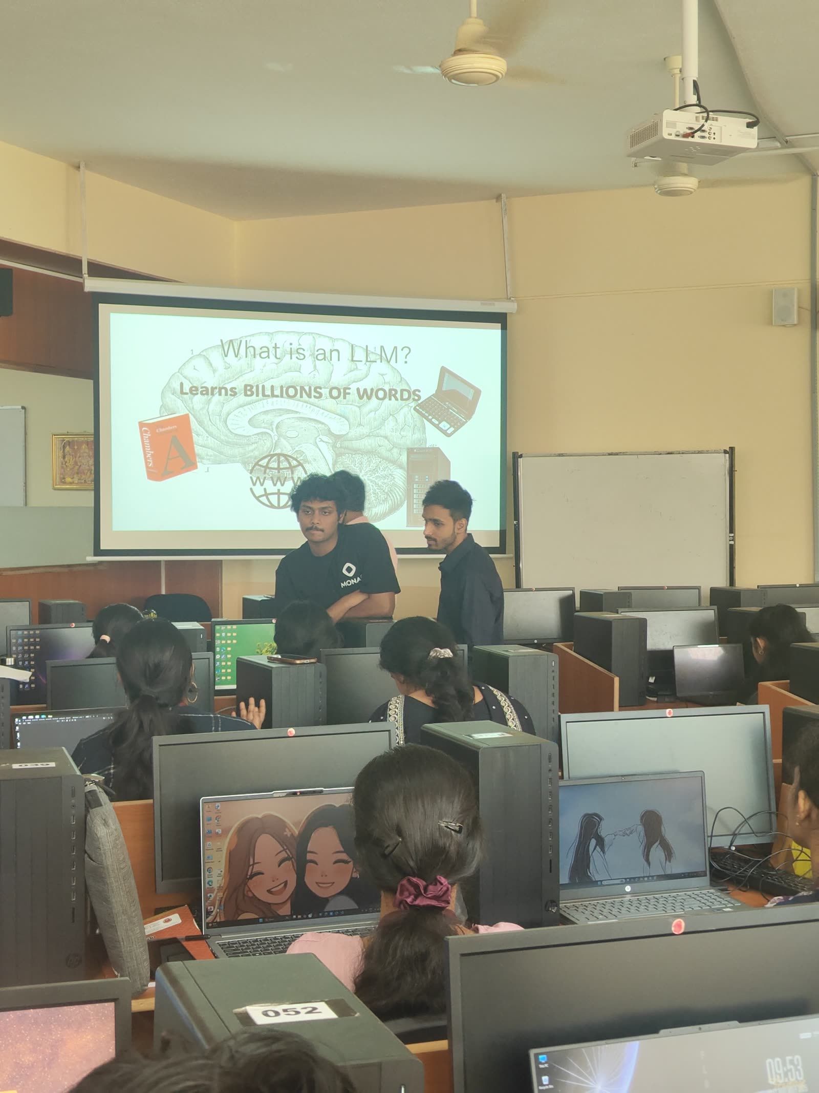 Instructors presenting "What is an LLM?" during an agentic AI workshop in a packed computer lab