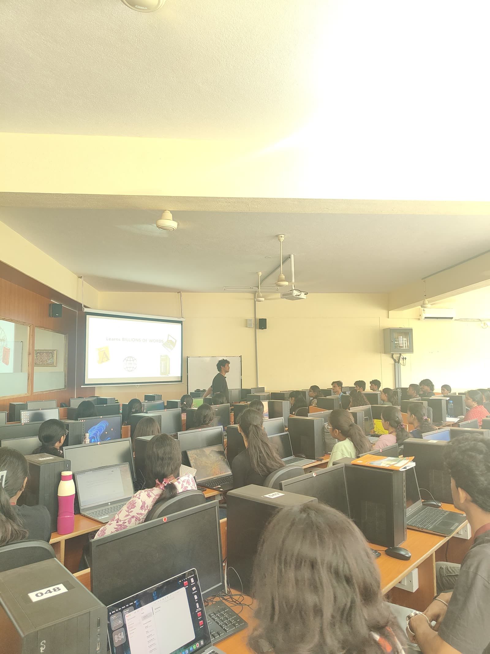 A full lab of students following a live demo on the projector